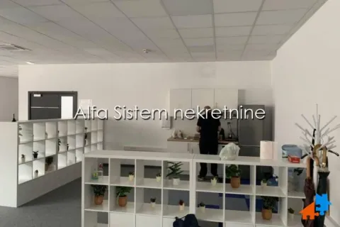 Office kitchen area with shelving units and a refrigerator. - image 7
