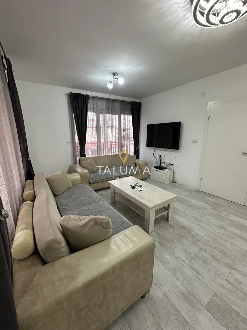 Living room with a sofa set, coffee table, and wall-mounted TV.