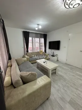 Living room with a sofa set, coffee table, and wall-mounted TV. - image 9