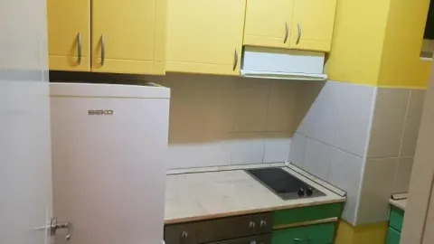 Smaller kitchen with yellow cabinets and a white refrigerator. - image 21