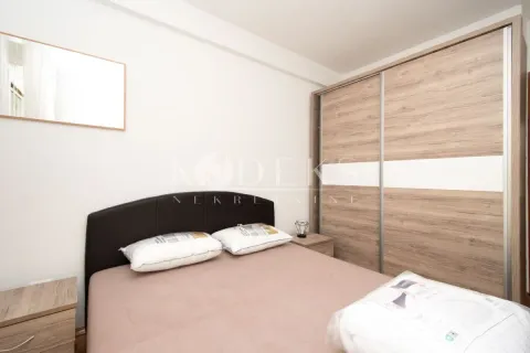 Spavaća soba sa bračnim krevetom, noćnim stočićima i velikim drvenim ormarom. - image 5