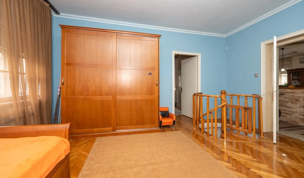 Bedroom with a large wooden wardrobe and a staircase.