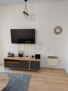 Dnevni boravak sa TV komodom i televizorom na zidu. - image 6