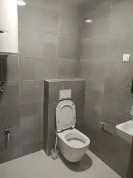 Moderno kupatilo sa sivim pločicama i ugradnim vodokotlićem. - image 6