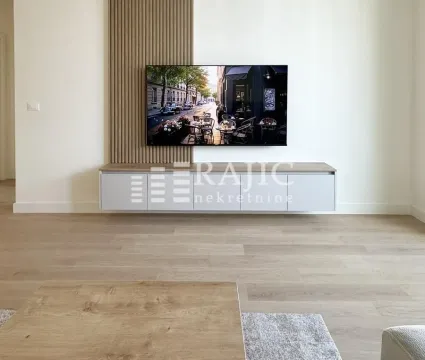 Living room with a TV, wooden wall panel, and console table. - image 5