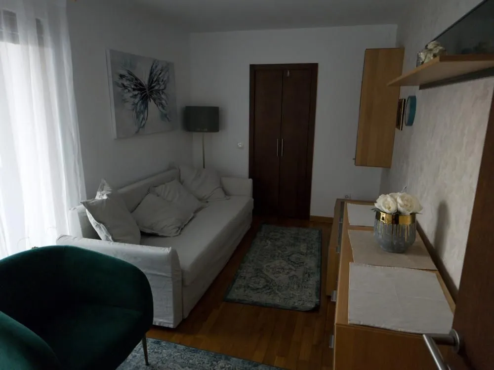 Manja dnevna soba sa kaučem, foteljom i komodom.