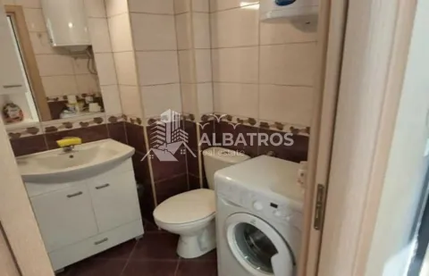 Small tiled bathroom equipped with a sink, toilet, and washing machine. - image 6