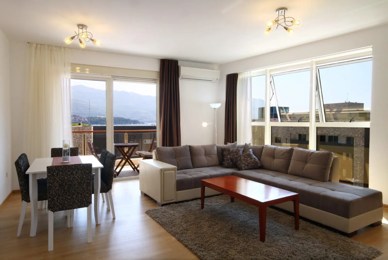 Spacious living room with a sofa, dining table, and access to a terrace with a sea view.