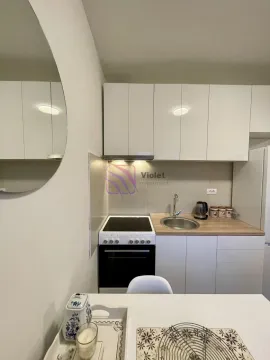 Small white kitchen with a stove, sink and upper cabinets. - image 4