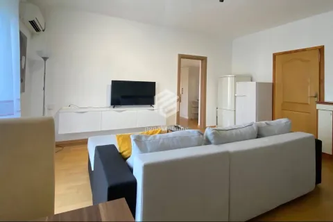 Dnevna soba sa ugaonom garniturom, televizorom i belom komodom. - image 10