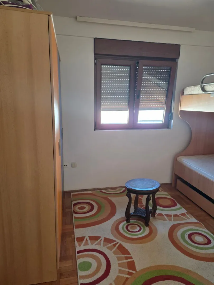 Bedroom with a bunk bed, wardrobe, and window.
