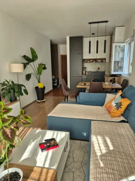 Living room with a sofa and view of the dining area and kitchen. - image 13