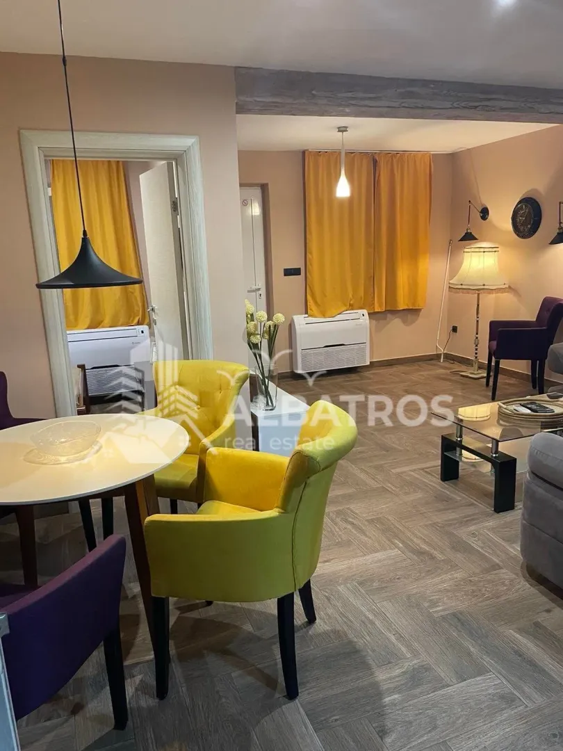 Living room with a dining area, sofa set, and yellow armchairs.