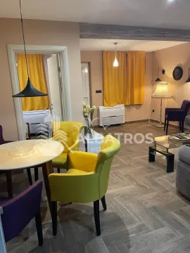 Living room with a dining area, sofa set, and yellow armchairs. - image 5