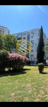 Pogled na stambenu zgradu sa uređenim dvorištem i zelenilom. - image 2
