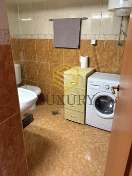 Smaller bathroom with sanitary fixtures, a cabinet, and a washing machine. - image 2