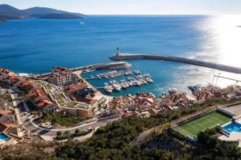 Pogled iz vazduha na obalu sa marinom, zgradama i plavim morem. - image 4