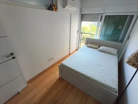 Bedroom with a double bed, wooden floor, and balcony access. - image 3