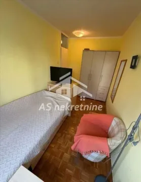 Small bedroom with a bed, wardrobe, armchair, and television. - image 13
