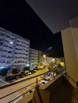 Pogled sa terase na osvijetljenu ulicu i zgrade noću. - image 9