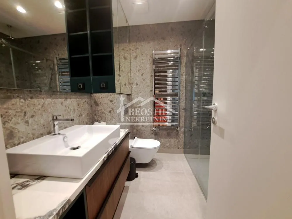 Modern bathroom with a washbasin, toilet, and walk-in shower.