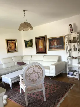 Bright living room with a white corner sofa and decorative armchair. - image 2