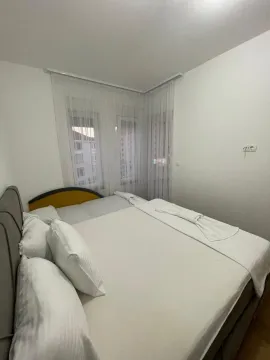 Svijetla spavaća soba sa bračnim krevetom i bijelom posteljinom. - image 7