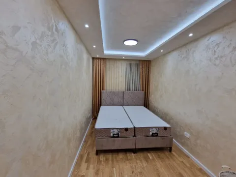 Bright bedroom featuring a double bed and decorative wall plastering. - image 6