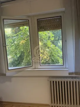 Pogled kroz prozor sa zelenilom i radijatorom ispod. - image 7