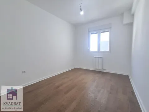 Prazna soba sa belim zidovima, parketom i jednim prozorom. - image 7