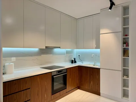 Modern kitchen with built-in units and white countertops. - image 3