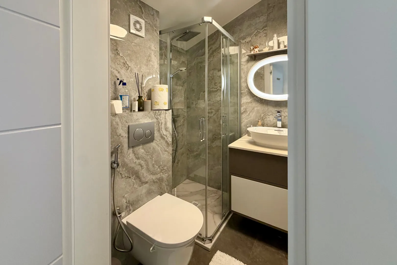 Moderno opremljeno kupatilo sa tuš kabinom, umivaonikom i wc šoljom.