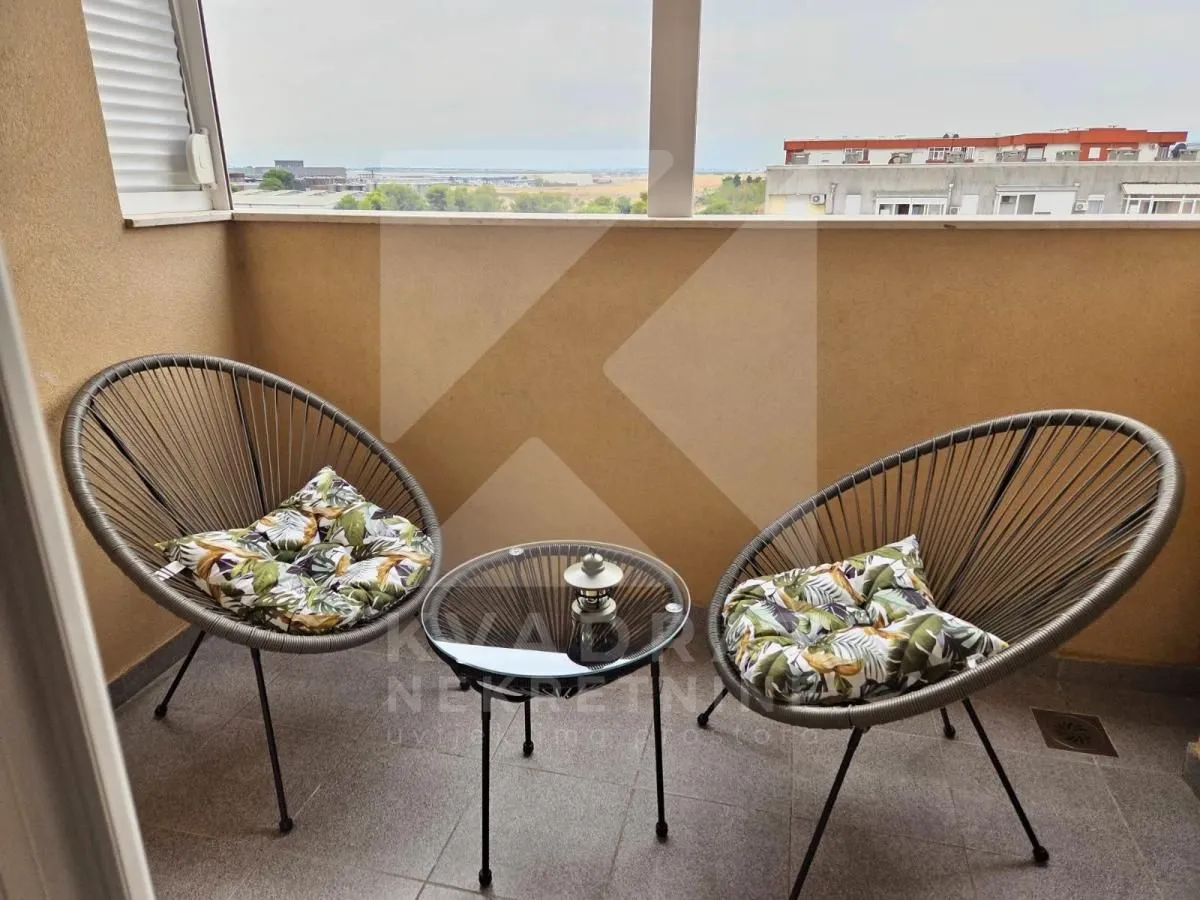 Natkriveni balkon sa dvije fotelje i stolićem.