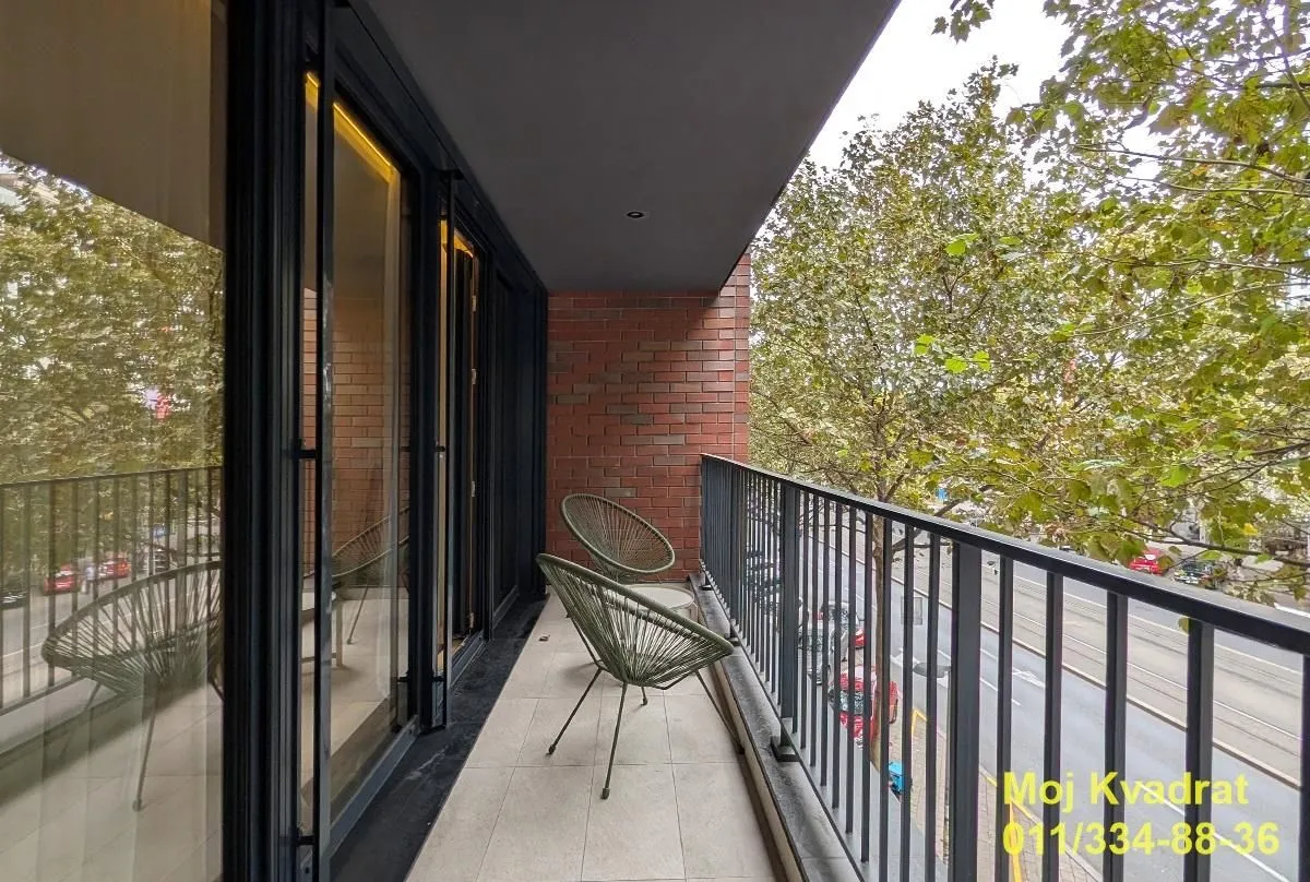 Furnished balcony with chairs and street view.