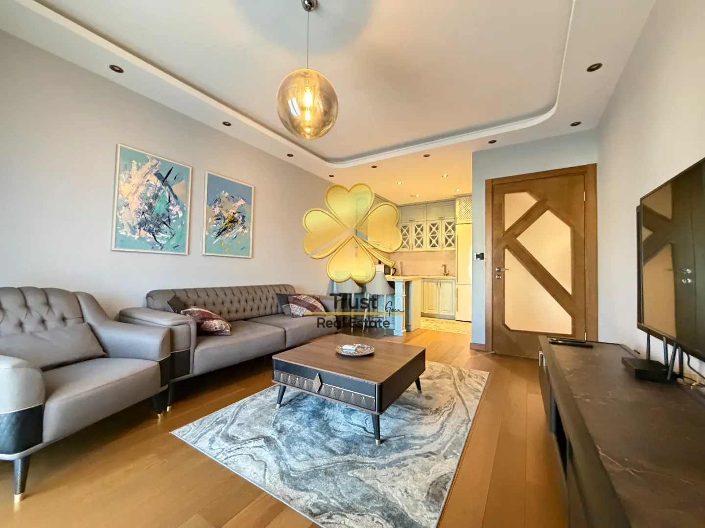 Modern living room with a sofa and a view of the kitchen.