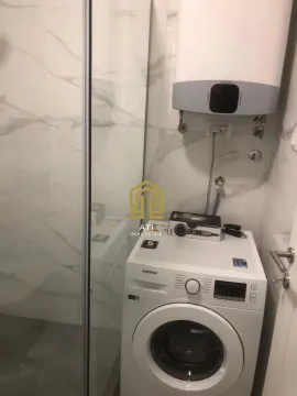 Small bathroom with a washing machine, water heater, and shower cabin. - image 19