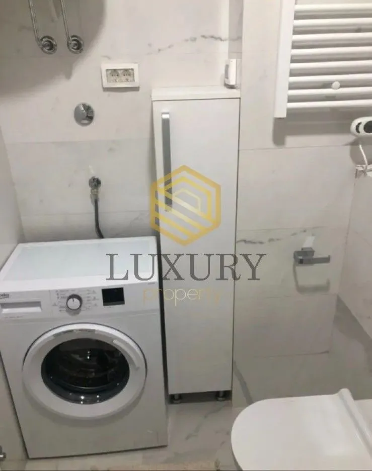 View of the bathroom with a washing machine and sanitary fixtures.