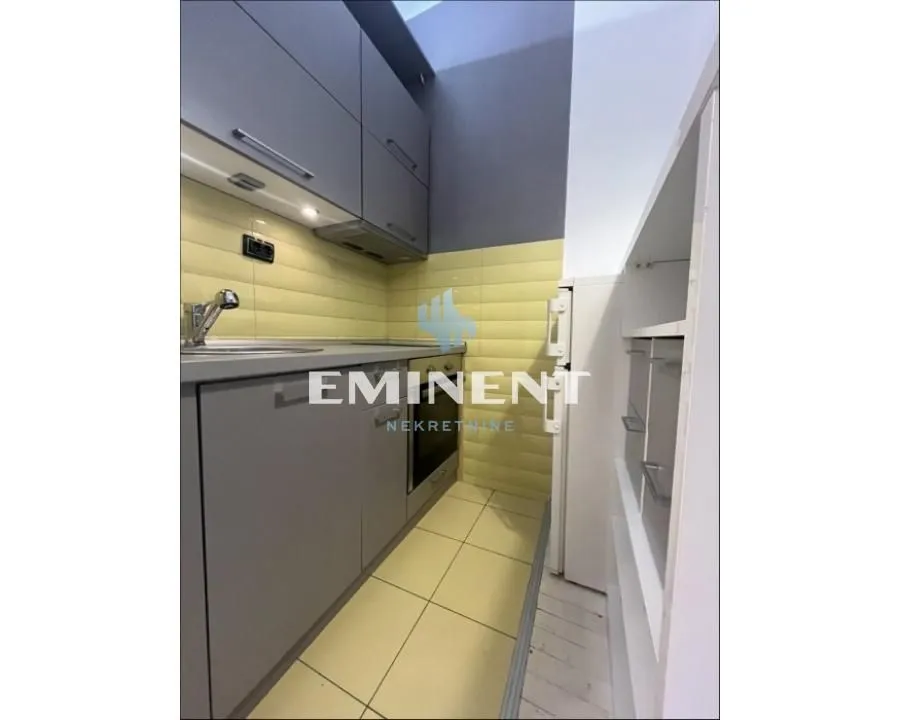 Small kitchen with grey cabinets and a built-in oven.