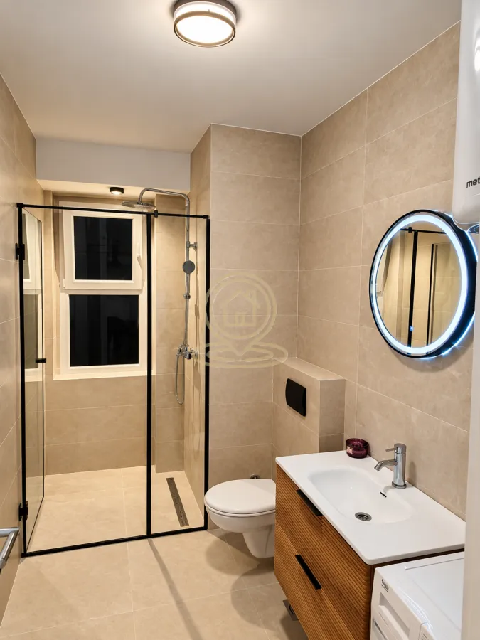 Modern bathroom with a walk-in shower, washbasin, and wall-hung toilet.