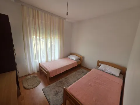 Bedroom with two wooden beds and a window with curtains. - image 10