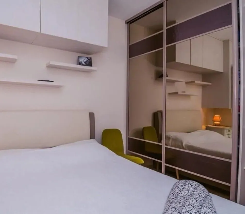 Furnished bedroom with a double bed and a large sliding wardrobe with mirrors.