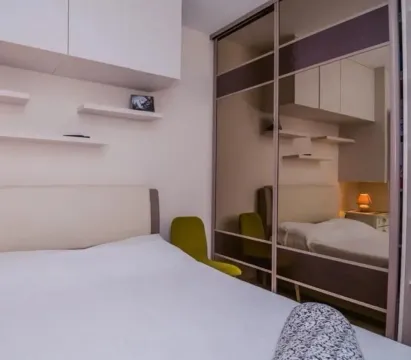 Furnished bedroom with a double bed and a large sliding wardrobe with mirrors. - image 4