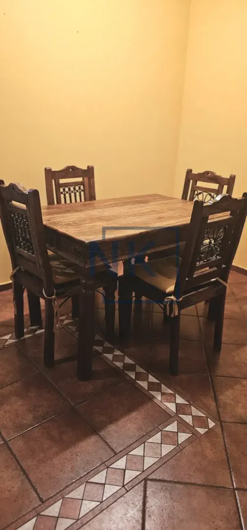 Drveni trpezarijski sto sa četiri stolice.
