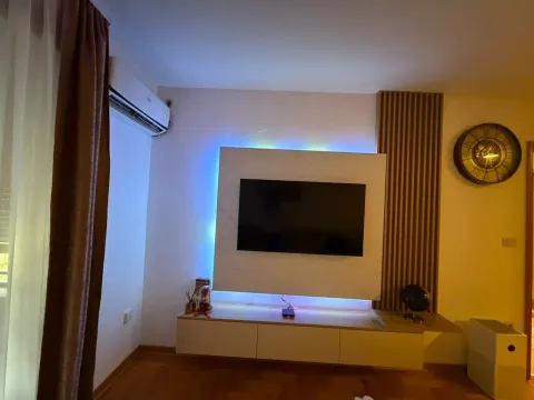 Dnevni boravak sa modernom televizijskom komodom i zidnim panelom. - image 3