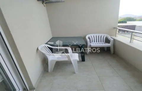 Covered terrace furnished with a plastic table and chairs. - image 9