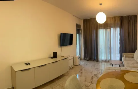 Living room with a sofa, TV, and dining table. - image 10