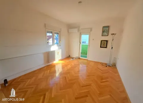 Prazna prostorija sa parketom, prozorom i vratima koja vode na terasu. - image 3