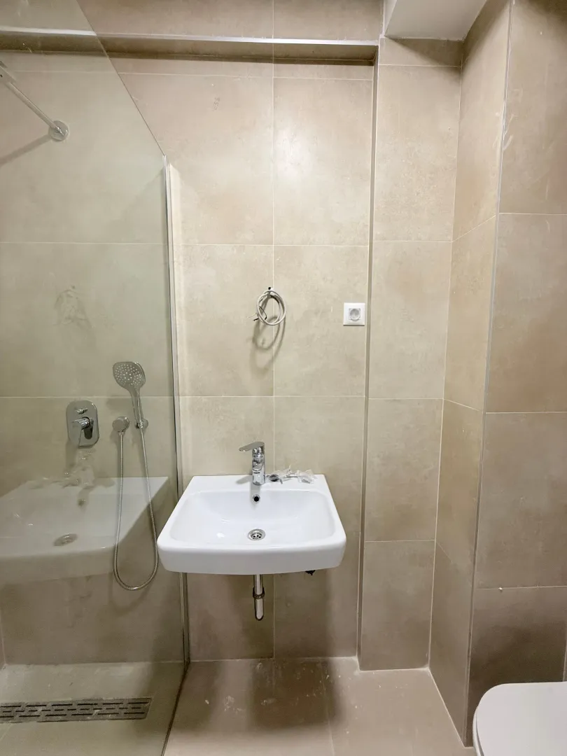 Moderne kupatilo sa umivaonikom i tuš kabinom.