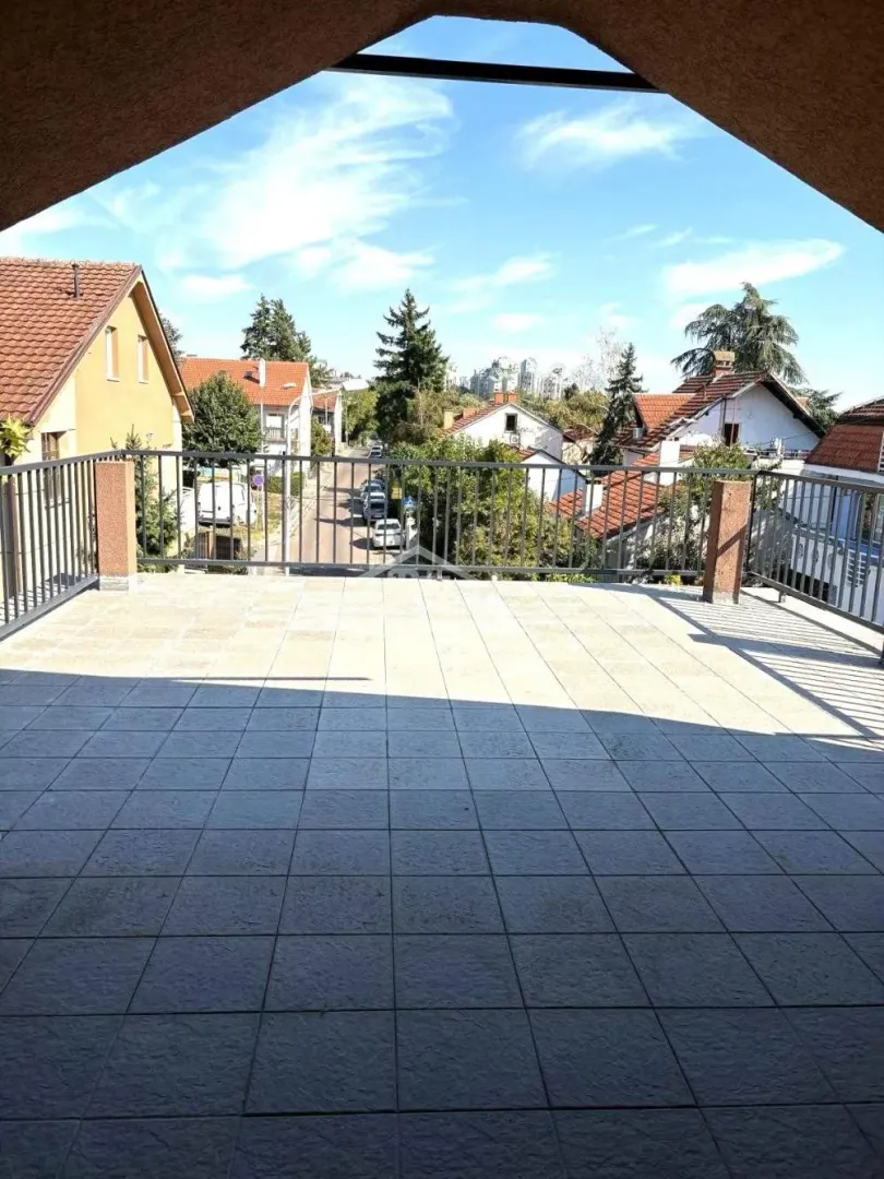 Large tiled terrace with a view of the surrounding neighborhood and street.