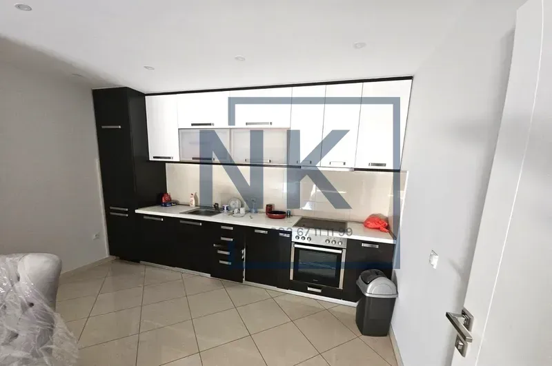 Kuhinja opremljena donjim i gornjim elementima i ugradnim kućnim aparatima.